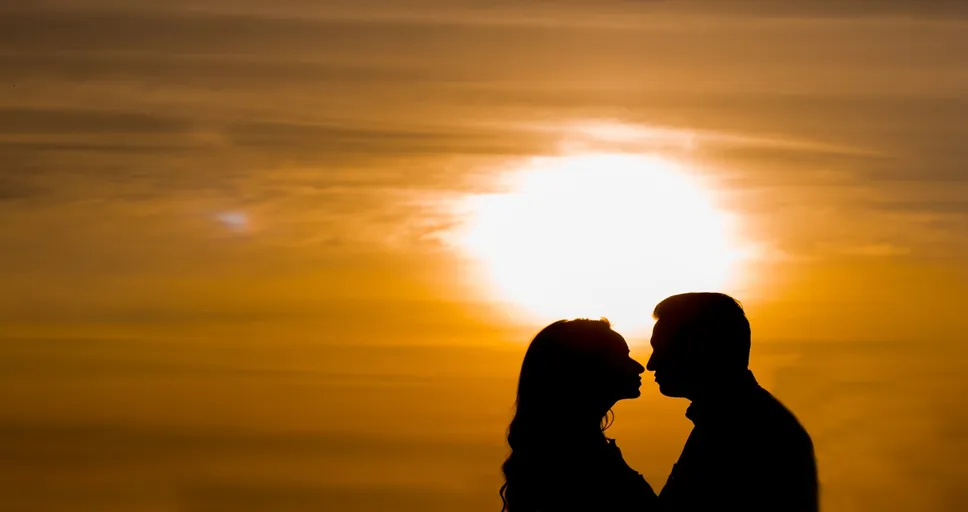 signs he wants you badly - couple, silhouette, sunset